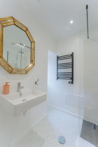 a white bathroom with a sink and a mirror at Madeira Surf Lodge in São Vicente