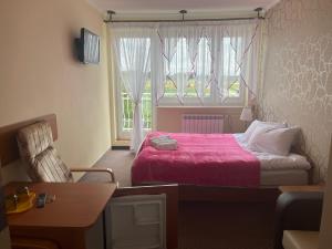 ウストロニエ・モルスキエにあるVilla Marlenaのベッドと窓が備わる小さな客室です。