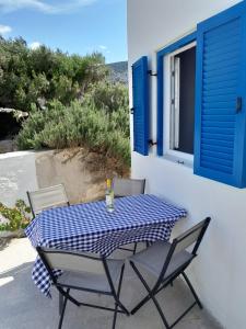 a table and chairs on a patio with a window at Spíti Catharina in Iraklia