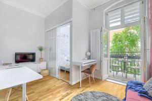 a white apartment with a desk and a balcony at Fair Point in Poznań