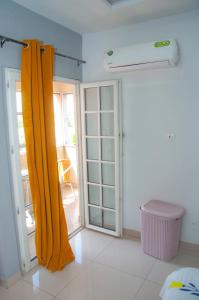 a room with a yellow curtain and a sliding glass door at Résidences 509 in Lomé