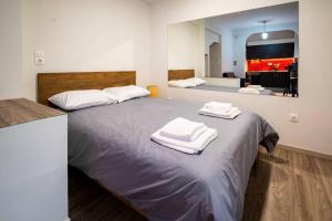 a large bed with two towels on top of it at Studio Apartment next to Alsos Ilision in Athens