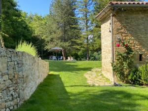 um jardim com uma parede de pedra e uma cerca de pedra em Weekend en Provence em Comps