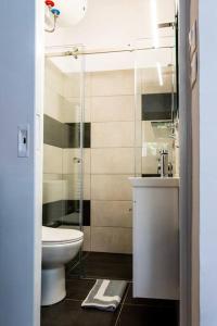 a bathroom with a toilet and a glass shower at Studio Apartment next to Alsos Ilision in Athens