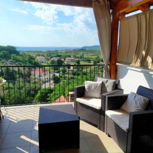 d'un balcon avec des chaises et une vue sur la campagne. dans l'établissement Apartment Cernesa, à Ražanac