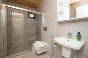 a bathroom with a toilet and a sink and a shower at Beyoglu Pansiyon in Patara