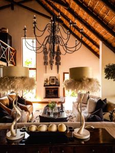 uma sala de estar com sofás e um lustre em Karongwe Portfolio - Kuname Lodge em Karongwe Game Reserve