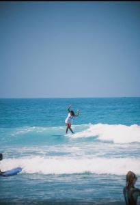 a woman riding a wave on a surfboard in the ocean at Onda Surf in Taghazout