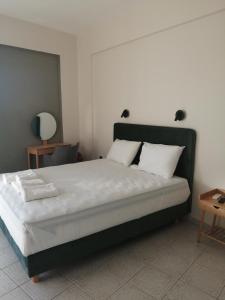 una camera da letto con un grande letto con cuscini bianchi di Filanthi CostaS a Stoupa