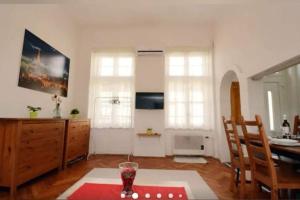 a living room with a table and some windows at Gallery flat in Party district in Budapest