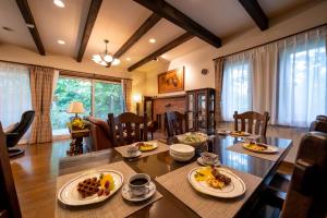 a dining room with a table with plates of food on it at スイートヴィラ アンジュール 小淵沢高原 in Iwa-kubo