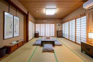 Zimmer mit einem Tisch, Bänken und Fenstern in der Unterkunft スイートヴィラ アンジュール 小淵沢高原 in Iwa-kubo