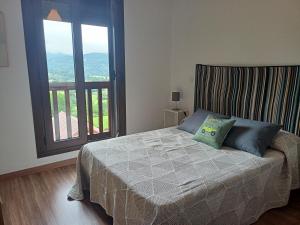 - une chambre avec un lit et une grande fenêtre dans l'établissement La Casa de Nuria, à Cangas de Onís