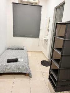 1 dormitorio con cama y estante negro en Ariesya Homestay, en Chemor