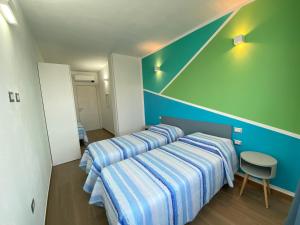 Habitación con 2 camas y pared azul en Casa Meli, en San Vero Milis