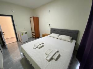 a bedroom with a white bed with two towels on it at Beyoglu Pansiyon in Patara