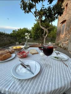 una mesa con platos de comida y una copa de vino en Sa Riba, Country house in Mallorca, en Son Carrió