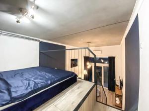 a bedroom with a blue bed and a balcony at Airport Apartment in Wrocław