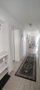 uma sala de estar com paredes brancas e um tapete em Apartment Lia em Beerfelden