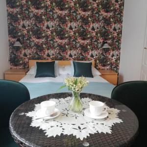 a table with a vase of flowers on top of a bedroom at Villa Karo in Łeba