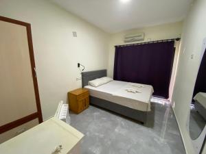 a small bedroom with a bed and a mirror at Beyoglu Pansiyon in Patara