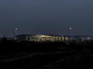 un gran edificio de noche con luces encendidas en Airport Apartment en Breslavia