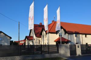 une rangée de maisons aux toits rouges et aux drapeaux dans l'établissement Piaskowy Dom, à Jantar