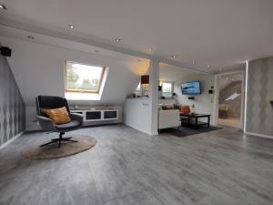 a living room with a chair and a couch at Ferienhaus Villa Adelsberg mit Dachterrasse in Zentraler Lage für bis zu 10 Personen in Chemnitz +83 photos