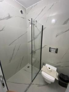 a bathroom with a glass shower and a toilet at Beyoglu Pansiyon in Patara