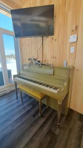 a green piano sitting in a room with a window at Les Chalets Double K # 2 in Saint-Alexis-des-Monts