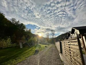 a cloudy sky over a yard with a fence at Relax and Smile Rameț in Biceşti