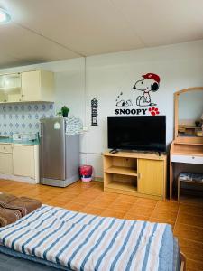 Habitación con cocina con TV y nevera. en For rent condo popular T8 fl8 en Thung Si Kan