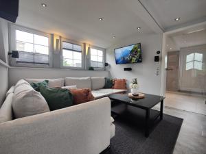 a living room with a white couch and a table at Ferienhaus Villa Adelsberg mit Dachterrasse in Zentraler Lage für bis zu 10 Personen in Chemnitz