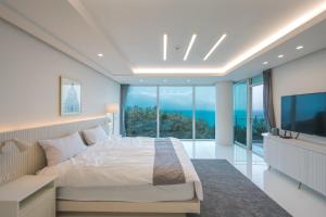 a bedroom with a large bed and a large window at 500m2 Busan Ocean view private Let house 부산 오션뷰 3개층 대저택 독채펜션 렛하우스 in Busan