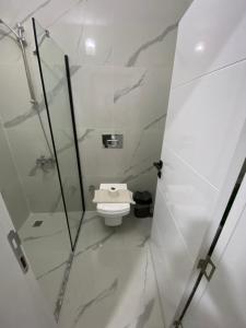 a bathroom with a toilet and a glass shower stall at Beyoglu Pansiyon in Patara