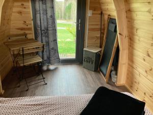 a room with a bed and a desk and a window at POD nature in Chazelles