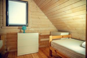 niewielka sypialnia z łóżkiem i oknem w obiekcie ZYGAdomki w Gąskach