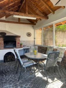 a patio with a table and chairs and a fireplace at Ferienhaus in Široki Brijeg