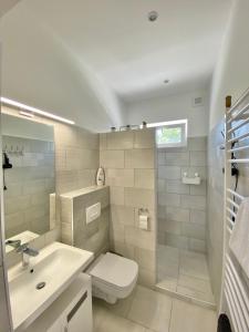 Baño blanco con aseo y lavamanos en Luca Apartman en Gyenesdiás