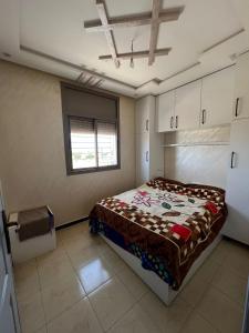 een slaapkamer met een bed in een kamer met een raam bij Belle résidence adrare tikouine agadir in Agadir