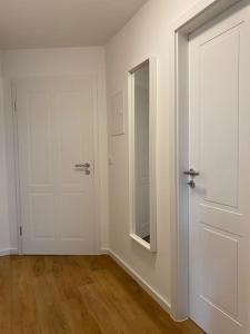 a white room with a door and a mirror at Apartment Nr. 3 Bad Laasphe Altstadt in Bad Laasphe