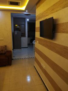 een woonkamer met een televisie aan de muur bij Belle résidence adrare tikouine agadir in Agadir