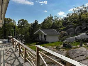 uma pequena casa numa colina com uma cerca de madeira em Kullavik, 2 mil från Göteborg Villa Gläntan em Kullavik