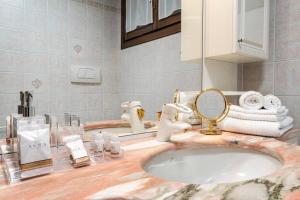 ein Bad mit einem Waschbecken und einem Spiegel in der Unterkunft Dante's Residence in Lido di Venezia