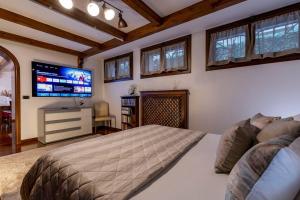 a bedroom with a bed and a flat screen tv at Dante's Residence in Venice-Lido
