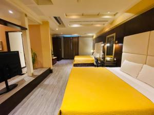 um quarto de hotel com duas camas e uma televisão em Holland Hill Motel em Tainan