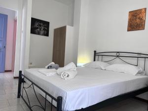 1 dormitorio con 1 cama con toallas en Λεμονιά Ενοικιαζόμενα δωμάτια, en Loutra Edipsou