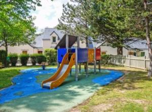 a playground with a slide in a yard at Maison au calme à l'intérieur du golf de Ploëmel, entre terre et mer, 2 chambres, 10 min des plages in Ploemel