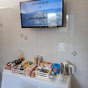 a tv on a wall above a table with food at A CASA IDA in Bagnoregio
