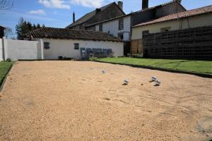 a yard with three balls on the ground in front of a house at Gites79 - Gite des Roses, 30mins Puy du Fou in Saint-Jouin-de-Milly